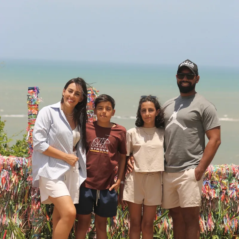 Jéssica e família com o mar ao fundo em Porto Seguro